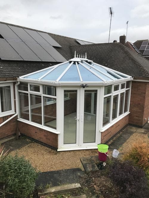 Victorian-style conservatory with a glass roof and finial