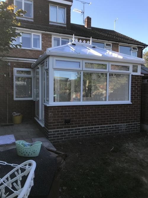 White Victorian conservatory with ornate roof finials