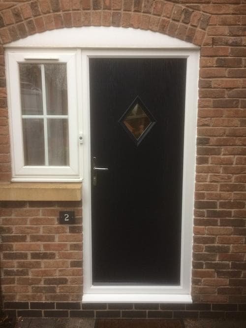 Black composite door with central diamond glazing