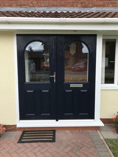 Navy stable-style double doors with arched glazing