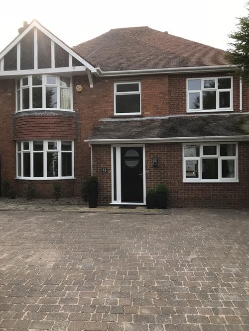 White bay and casement windows on a large brick house