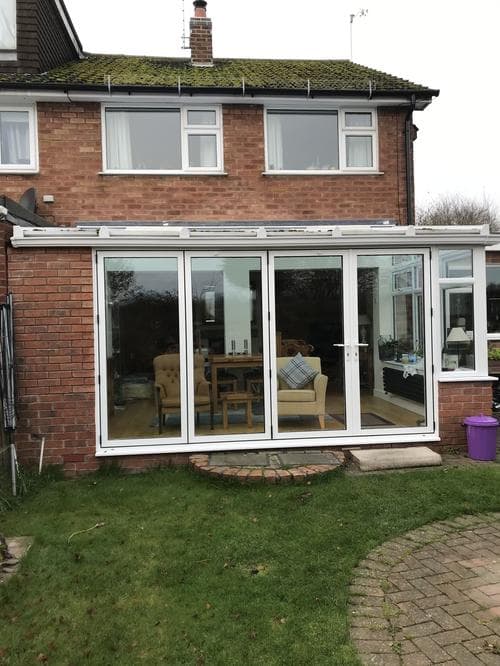 White bi-fold doors and windows on a garden room extension