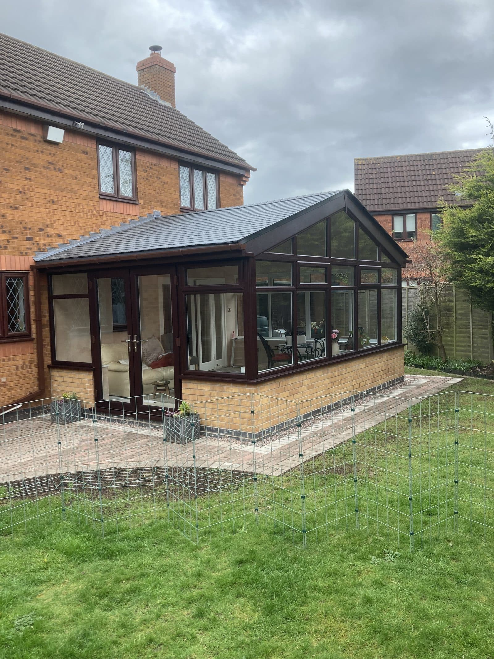 Conservatory installation with dark woodgrain frames